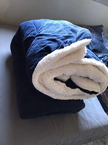 Coberdrom sherpa azul marinho dobrado mostrando o lado peluciado